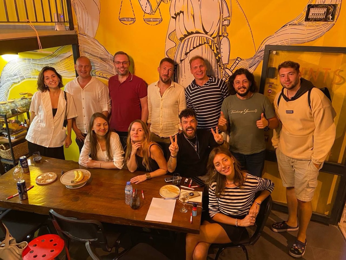 The Web3 Hub Kaş community around the long table under the justice mural