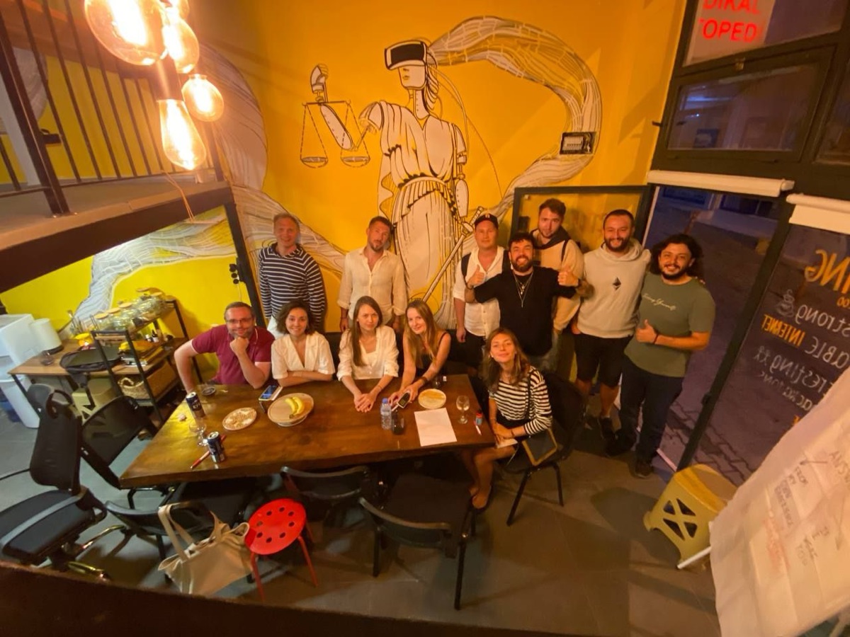 The community gathered for a group photo under the justice mural