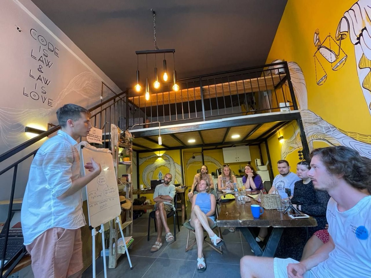 The two-level hub space with the community gathered under the justice mural