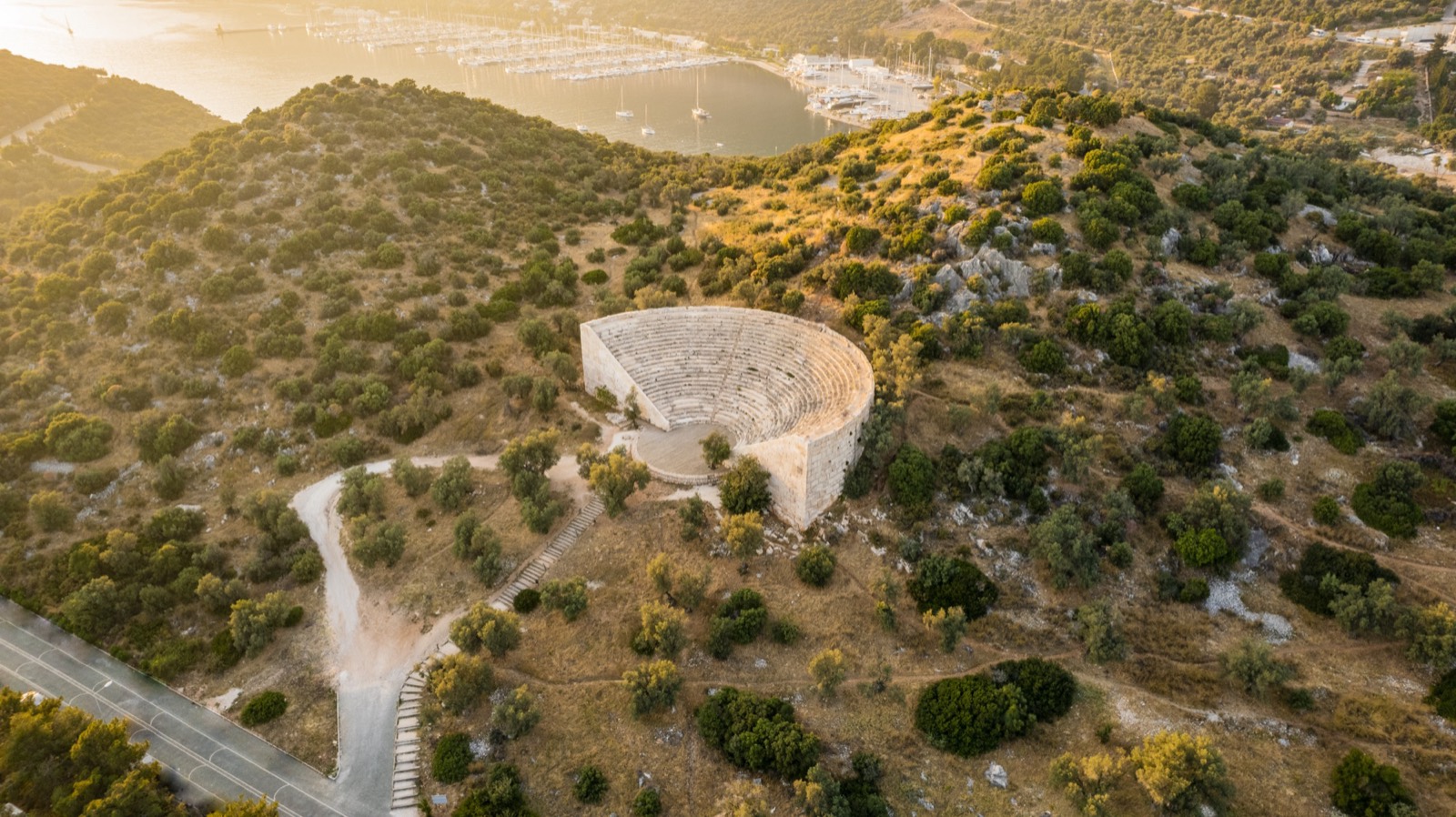 The ancient theater of Antiphellos at golden hour above the marina