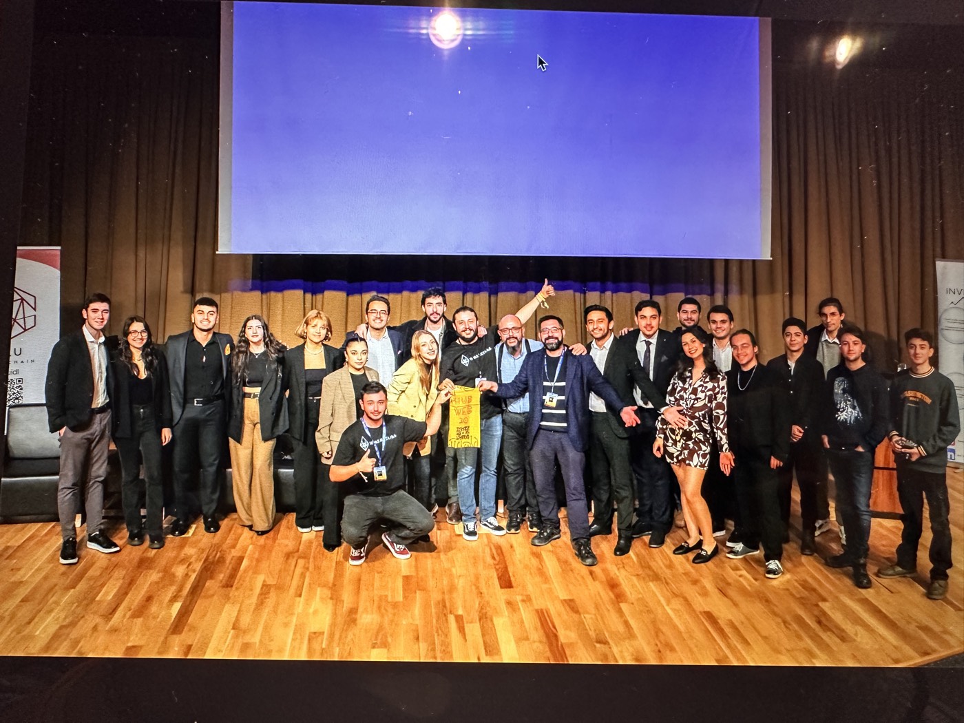 Community on stage at a university blockchain event