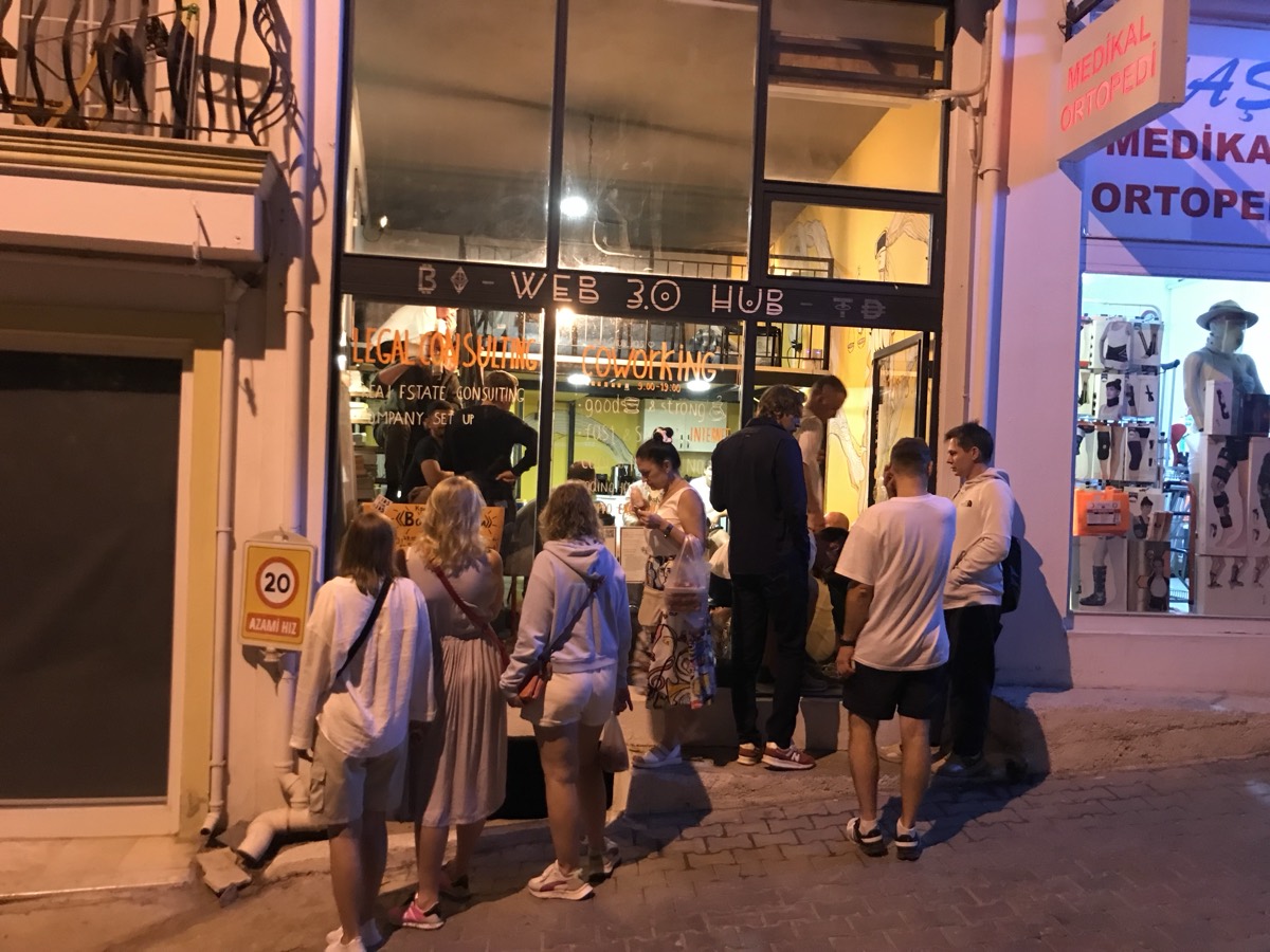 The Web 3.0 Hub storefront at night with a crowd outside